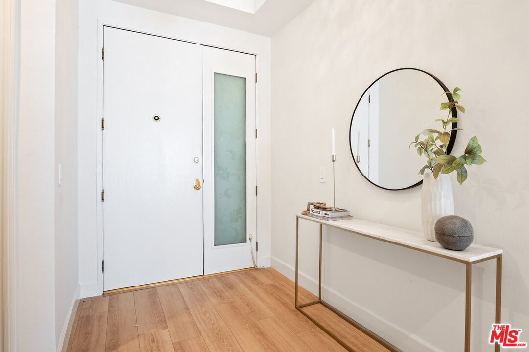457 North Doheny Drive, Unit 304 Beverly Hills, CA 90210 - Photo 28 of 32 a view of a room with wooden floor and mirror