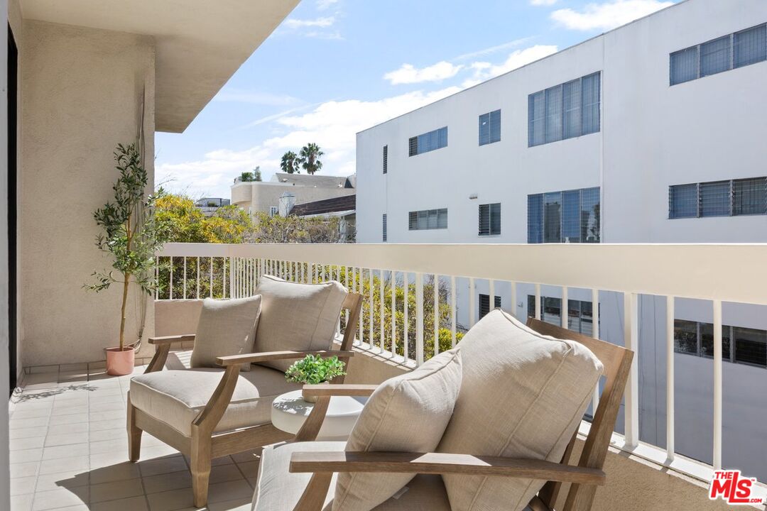 457 North Doheny Drive, Unit 304 Beverly Hills, CA 90210 - Photo 29 of 32 a roof deck with a table and chairs