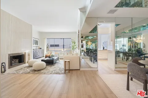 a living room with furniture a fireplace and a floor to ceiling window