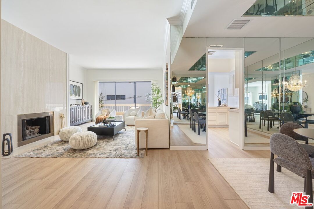 457 North Doheny Drive, Unit 304 Beverly Hills, CA 90210 - Photo 6 of 32 a living room with furniture a fireplace and a floor to ceiling window
