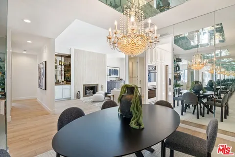a view of a dining room with furniture a chandelier and wooden floor