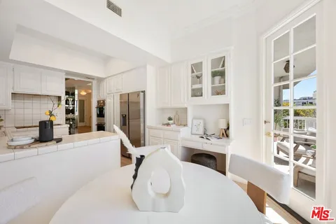 a kitchen with stainless steel appliances kitchen island granite countertop a refrigerator and a sink