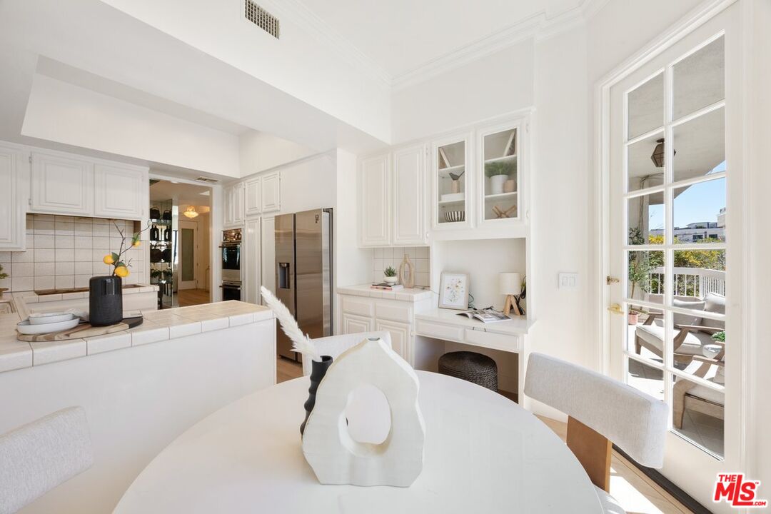457 North Doheny Drive, Unit 304 Beverly Hills, CA 90210 - Photo 10 of 32 a kitchen with stainless steel appliances kitchen island granite countertop a refrigerator and a sink
