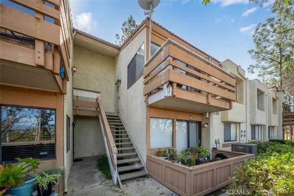 a view of a chair and table in the back yard of the house