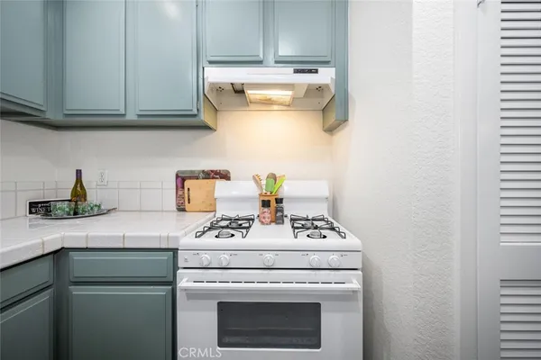 a kitchen with granite countertop a stove and a microwave