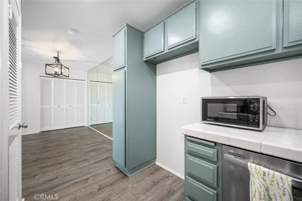 a kitchen with a stove cabinets and wooden floor