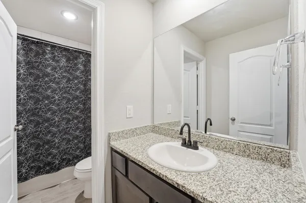 a bathroom with a granite countertop sink and a mirror