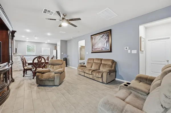 a living room with furniture and a ceiling fan