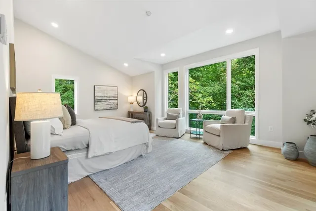 a bedroom with furniture and a large window