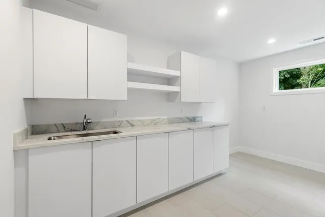 a room with a sink cabinets and a window