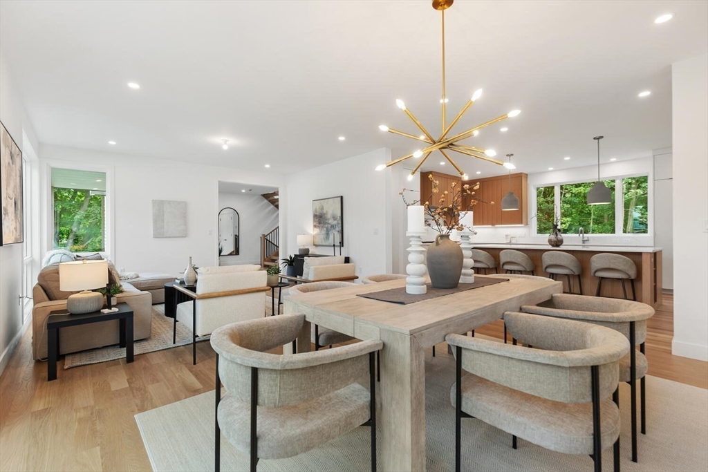 6 Linc Cole Lane Lexington, MA 02421 - Photo 6 of 30 a view of a dining room and livingroom with furniture a rug a fireplace and a chandelier