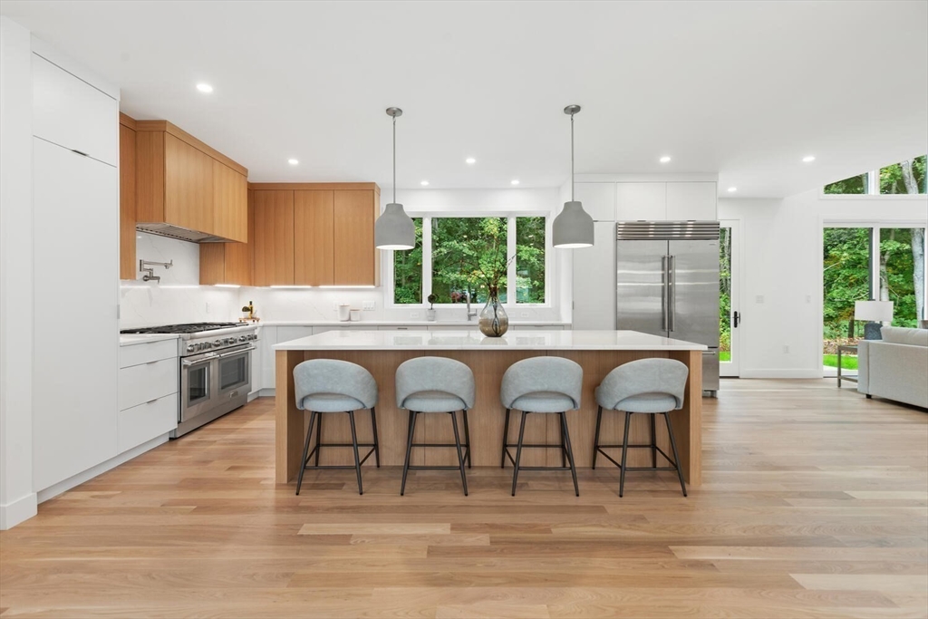 6 Linc Cole Lane Lexington, MA 02421 - Photo 7 of 30 a kitchen with stainless steel appliances granite countertop a stove top oven a sink dishwasher and white cabinets with wooden floor