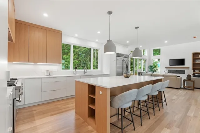 a kitchen with kitchen island granite countertop a table chairs sink and cabinets