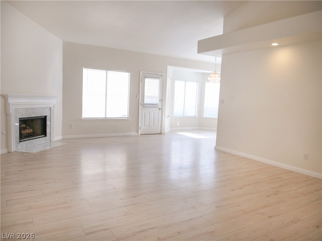 Laminate flooring sweeps through an airy living space with a classic fireplace.