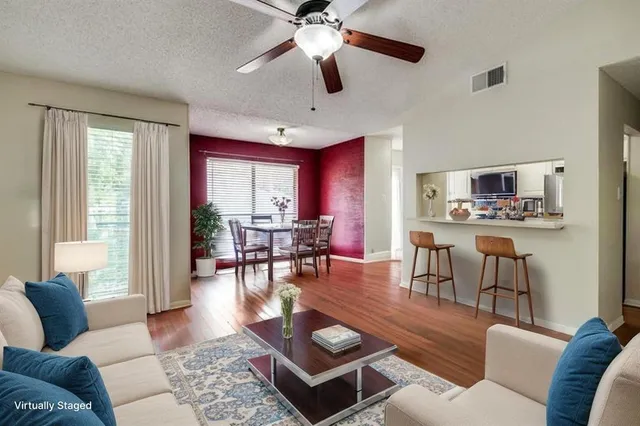 a living room with furniture a wooden floor and a window