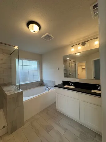 an empty room with a ceiling fan and windows