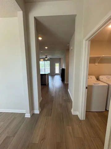 view of a hallway with wooden floor and furniture
