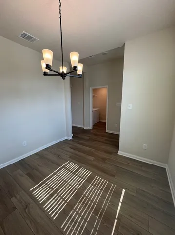 a view of a room with a ceiling fan and wooden floor