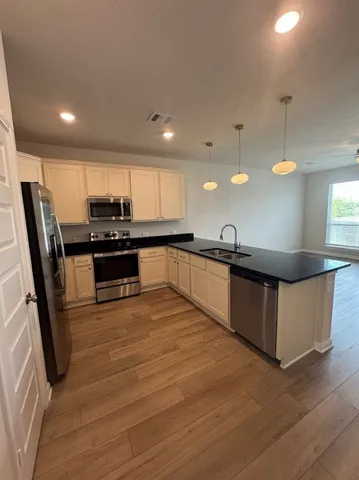 a kitchen with stainless steel appliances kitchen island granite countertop a stove a sink and a microwave