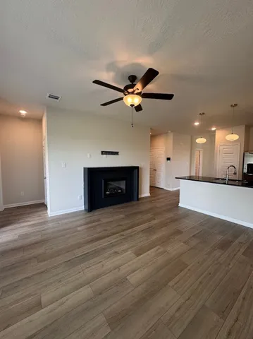 a large white kitchen with a white countertops a wooden floor and a fireplace
