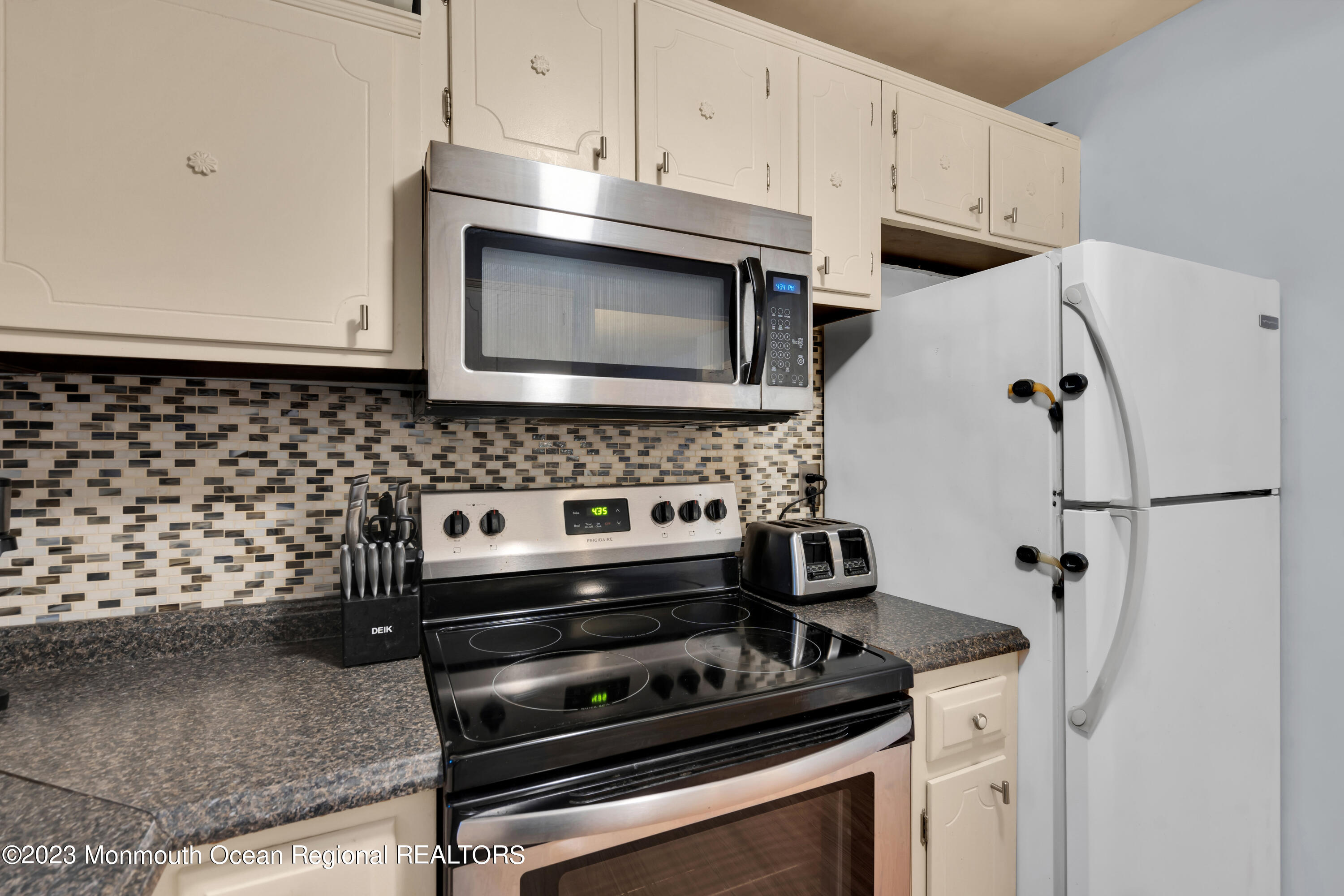 142 Azalea Drive, Unit B Whiting, NJ 08759 - Photo 15 of 27 a kitchen with granite countertop a stove and a microwave