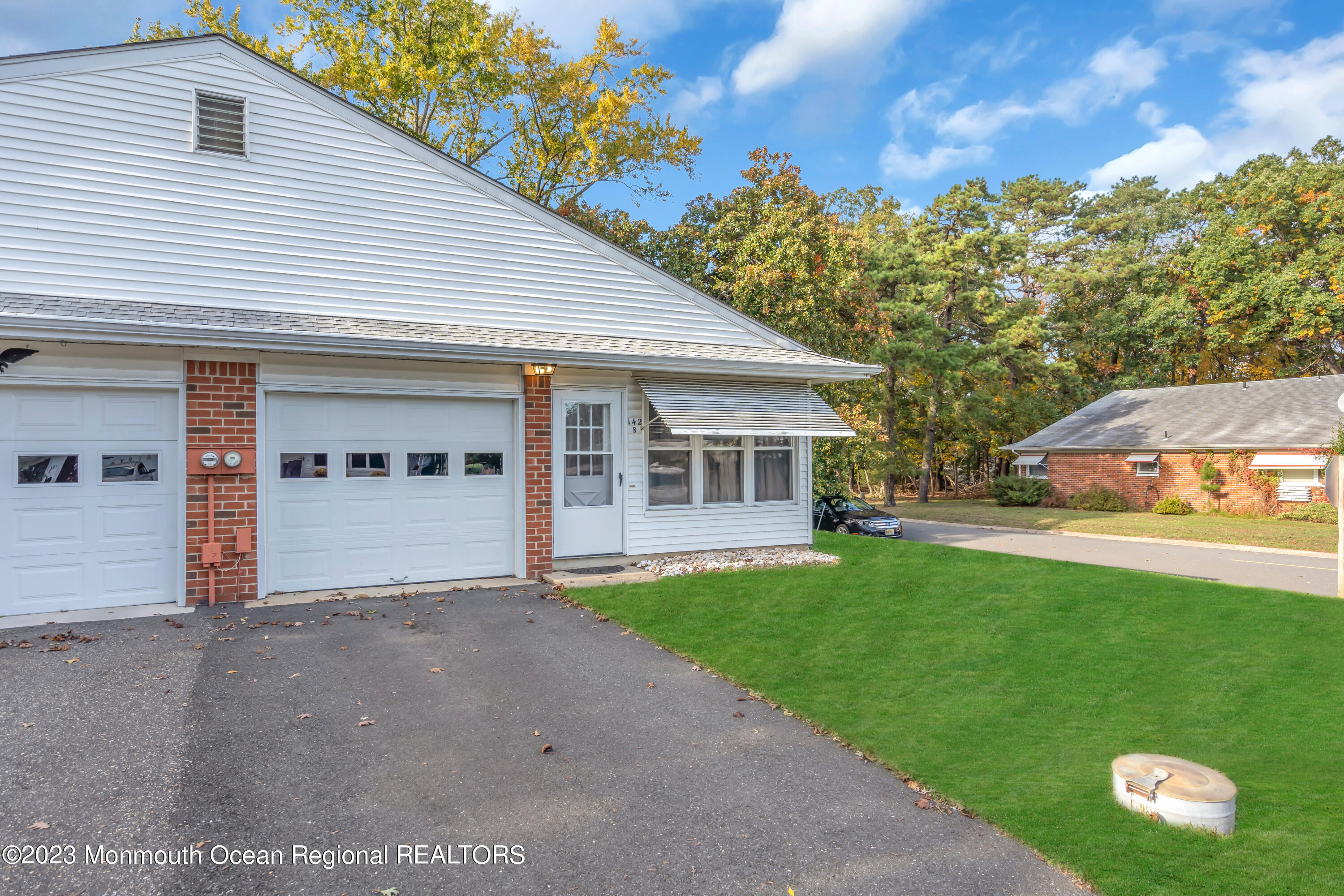 142 Azalea Drive, Unit B Whiting, NJ 08759 - Photo 4 of 27 a front view of a house with a yard and garage