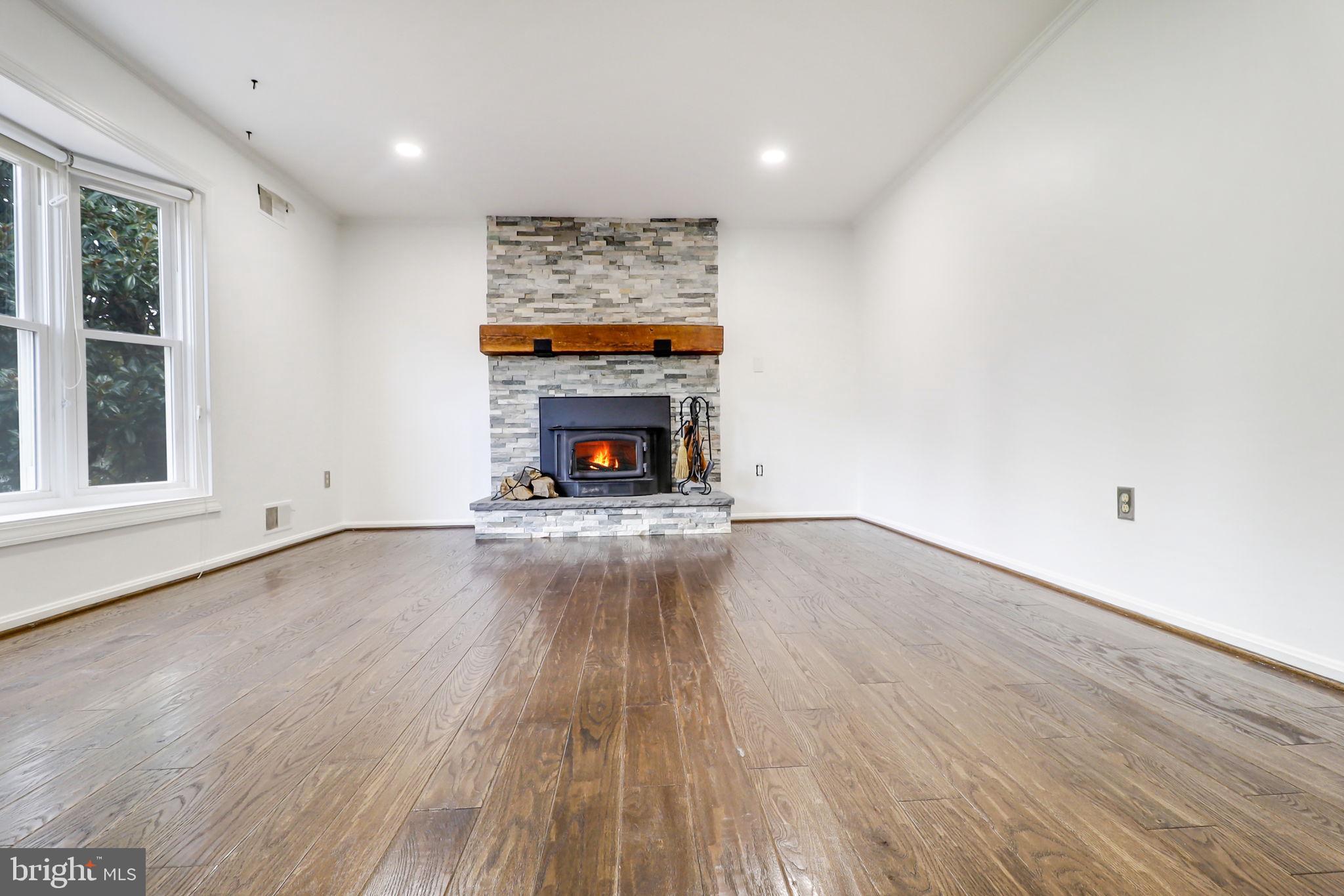 21960 Oatlands Road Aldie, VA 20105 - Photo 26 of 79 an empty room with wooden floor a fireplace and a window