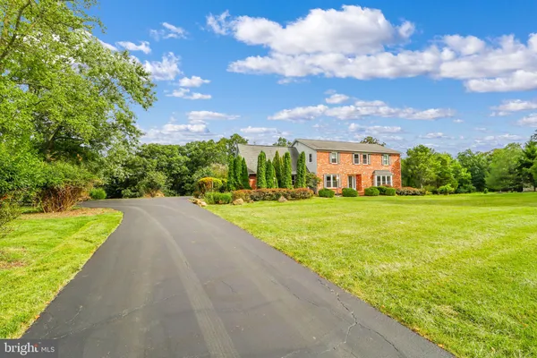a view of a house with a big yard and large trees