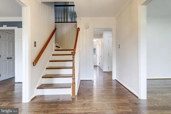 an empty room with wooden floor cabinet and a ceiling fan