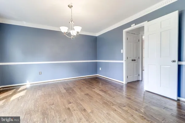 a view of a hallway with wooden floor and stairs
