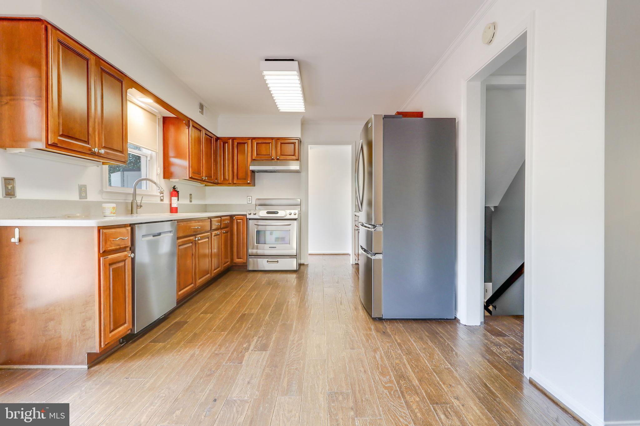 21960 Oatlands Road Aldie, VA 20105 - Photo 42 of 79 a kitchen with stainless steel appliances granite countertop a refrigerator a sink dishwasher and wooden cabinets with wooden floor