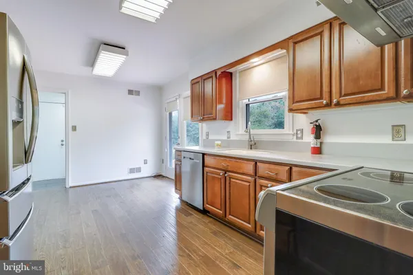 an empty room with wooden floor ceiling fan and windows