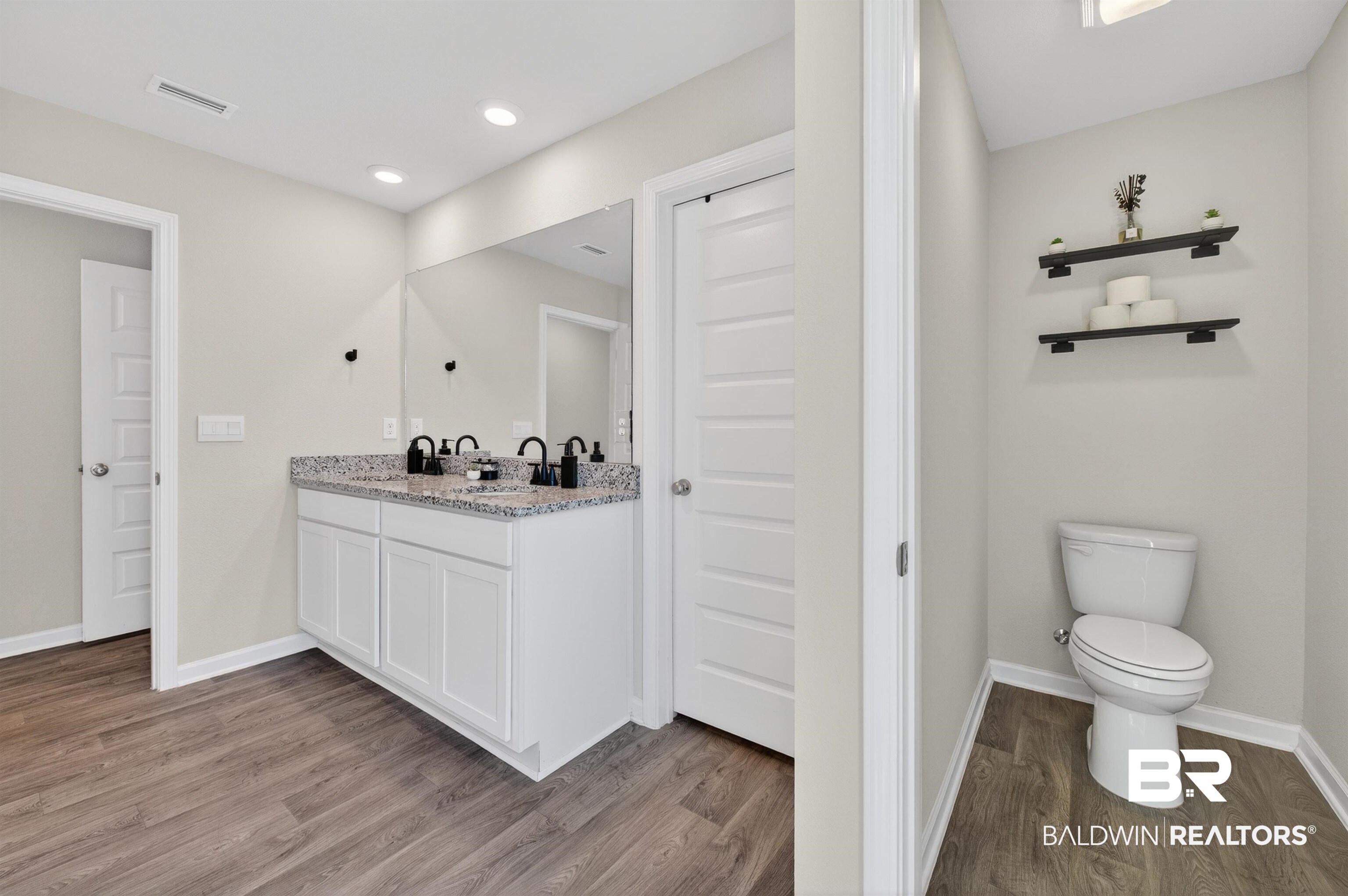3213 Camino Real Loop Lillian, AL 36549 - Photo 41 of 61 Bathroom featuring a double vanity with a speckled countertop, matte black fixtures, and wood-finish flooring