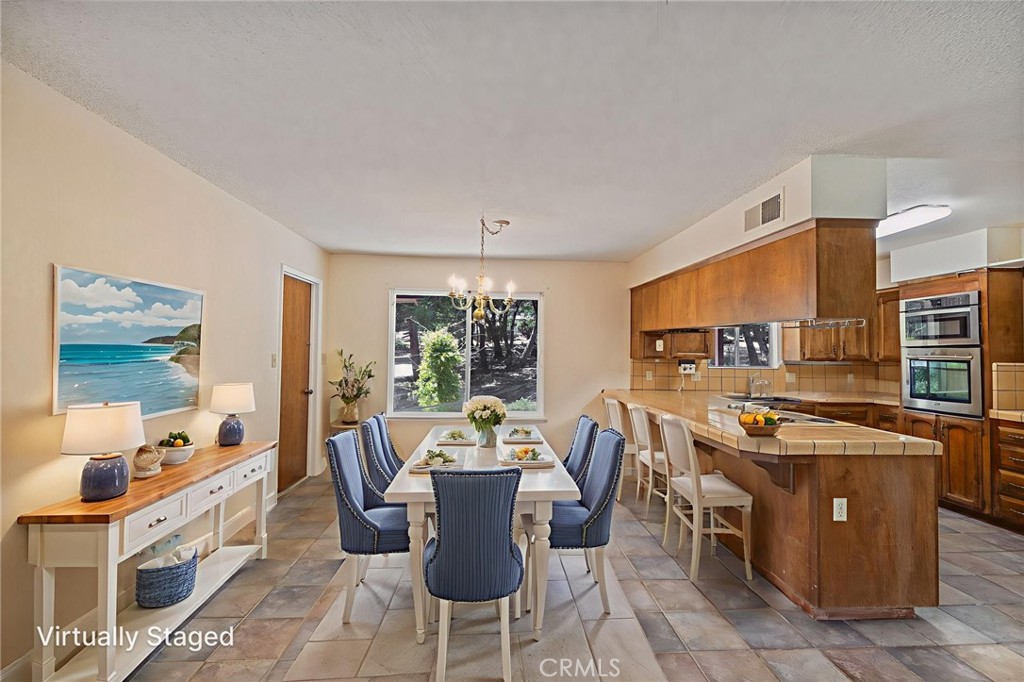 a open dining room with stainless steel appliances a dining table and chairs