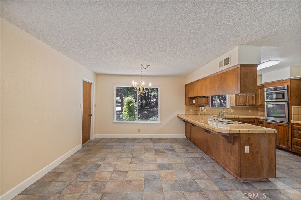 32413 Chickasaw Road Coarsegold, CA 93614 - Photo 22 of 66 a large kitchen with stainless steel appliances granite countertop a stove a sink and a refrigerator