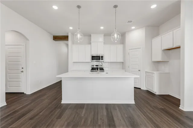 a view of kitchen with stainless steel appliances granite countertop a stove a sink and a refrigerator