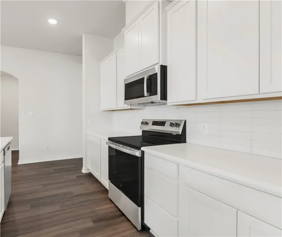 a kitchen with stainless steel appliances granite countertop a stove microwave and sink