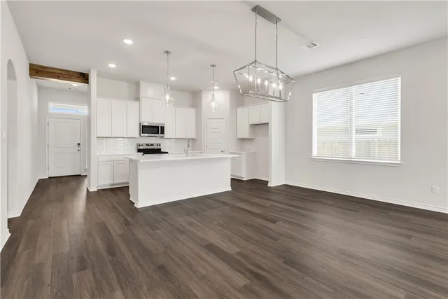 a view of a kitchen with wooden floor and stainless steel appliances