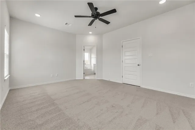 an empty room with chandelier fan
