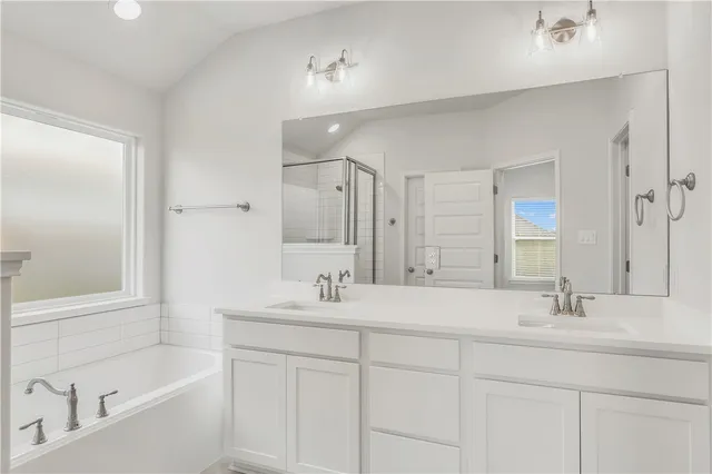 a bathroom with 2 sink tub and a mirror