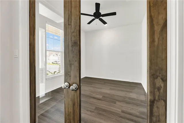a view of a room with wooden floor closet and windows