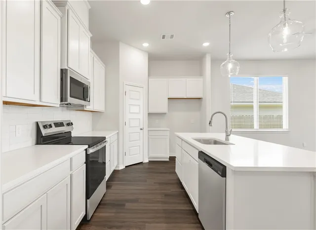 a kitchen with a sink stove top oven and microwave