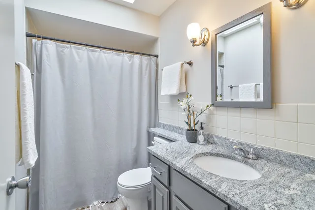 a bathroom with a granite countertop sink and a mirror