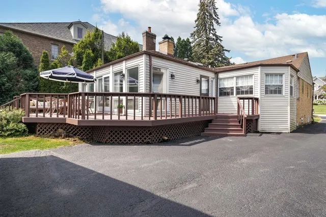 a view of a house with a wooden deck and a yard