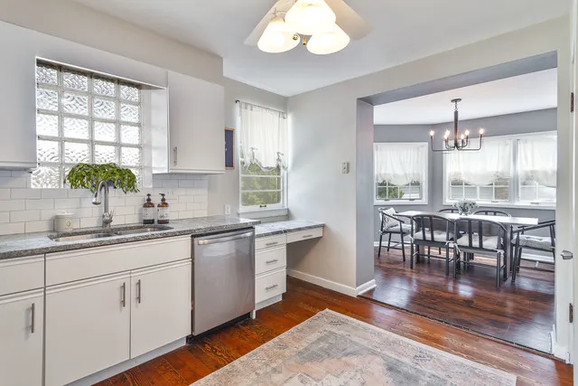 a kitchen with stainless steel appliances granite countertop wooden floors and white cabinets