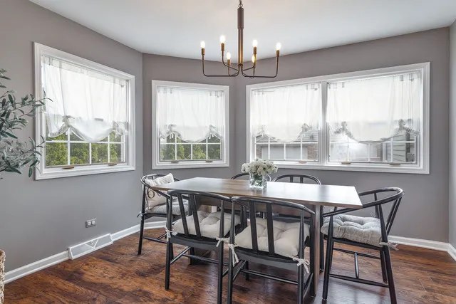 a dining room with furniture window and wooden floor