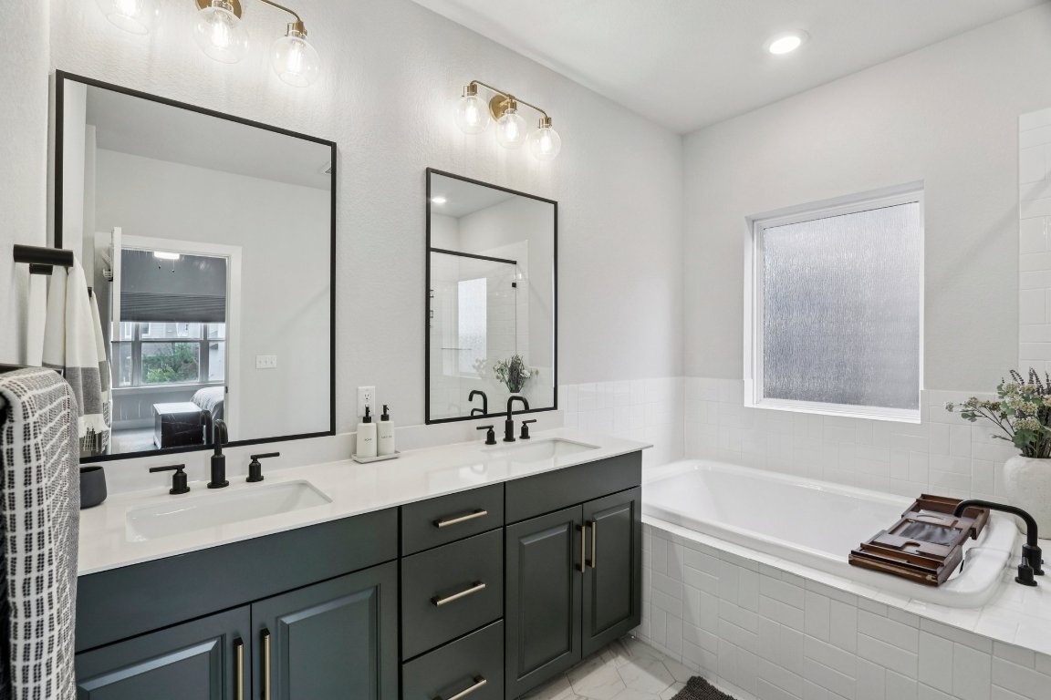 6001 McMurtry Street Austin, TX 78747 - Photo 12 of 26 a bathroom with a tub double sink and mirror