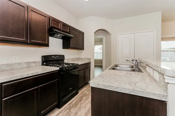 a kitchen with stainless steel appliances granite countertop a sink stove and cabinets