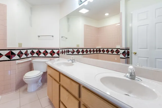 a bathroom with a granite countertop sink a toilet and shower