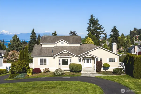 a front view of house with yard and trees in the background